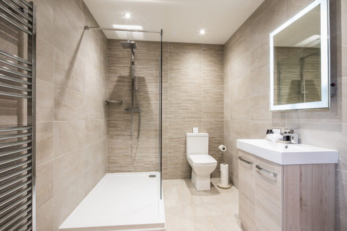 Newly installed modern bathroom suite featuring a clean white sink, toilet, and walk-in shower, showcasing expert bathroom installation services.