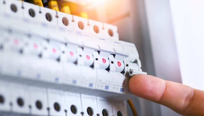 Close-up of a domestic fuse box showing circuit breakers, highlighting electrical safety and control.